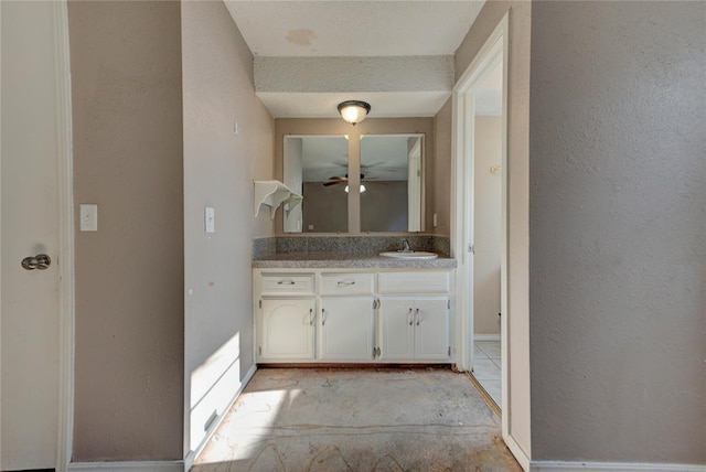 1021 SW 1st St, Moore, OK 73160 - bathroom featuring vanity, a textured wall, and a ceiling fan