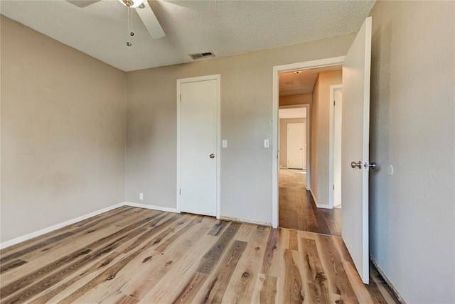 1021 SW 1st St, Moore, OK 73160 - unfurnished bedroom featuring wood finished floors, a ceiling fan, and a textured ceiling