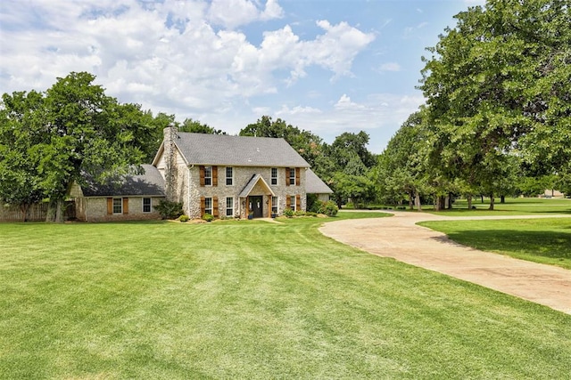 5305 Circle Gln, Edmond, OK 73025 - colonial inspired home with a front yard, stone siding, and a chimney