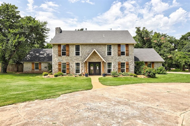 5305 Circle Gln, Edmond, OK 73025 - colonial-style house with stone siding, french doors, and a chimney