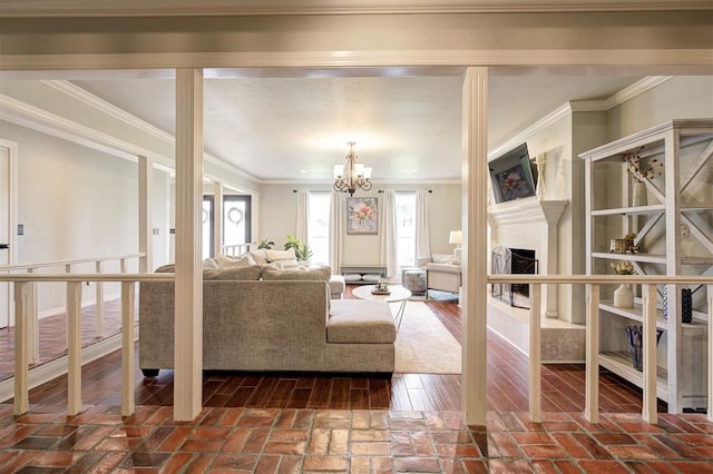 5305 Circle Gln, Edmond, OK 73025 - living area featuring a fireplace, a chandelier, brick flooring, and ornamental molding