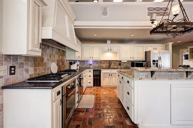 5305 Circle Gln, Edmond, OK 73025 - kitchen featuring stainless steel appliances, wine cooler, brick flooring, a chandelier, and tasteful backsplash