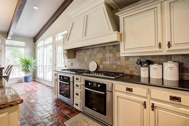 5305 Circle Gln, Edmond, OK 73025 - kitchen with stainless steel appliances, cream cabinetry, decorative backsplash, brick flooring, and recessed lighting