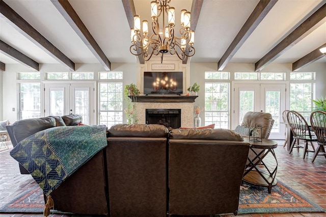 5305 Circle Gln, Edmond, OK 73025 - living room with beam ceiling, french doors, a fireplace, a chandelier, and brick flooring