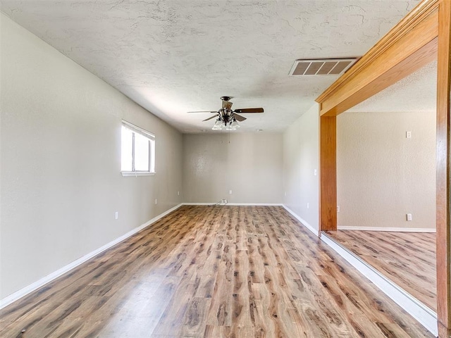 2618 NW Apache Rd, Piedmont, OK 73078 - empty room featuring a ceiling fan, wood finished floors, and a textured ceiling