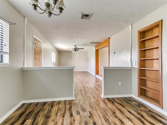 2618 NW Apache Rd, Piedmont, OK 73078 - spare room with wood finished floors, built in shelves, a chandelier, and a textured ceiling