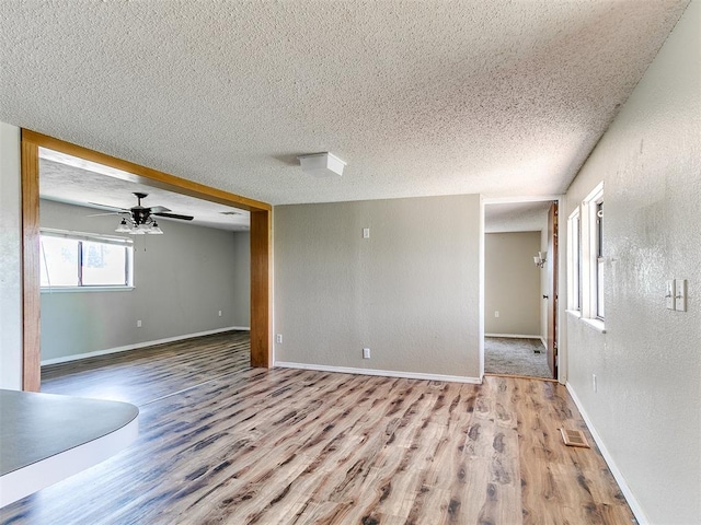 2618 NW Apache Rd, Piedmont, OK 73078 - spare room with wood finished floors, a textured ceiling, ceiling fan, and a textured wall
