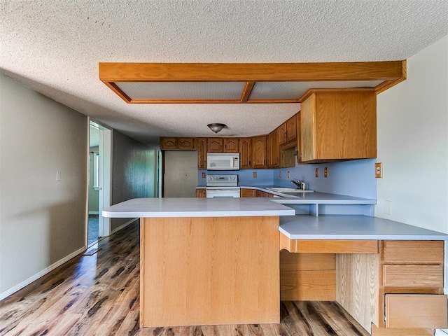 2618 NW Apache Rd, Piedmont, OK 73078 - kitchen featuring white appliances, wood finished floors, a textured ceiling, light countertops, and brown cabinetry