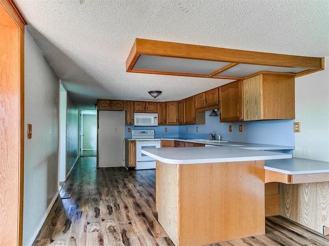 2618 NW Apache Rd, Piedmont, OK 73078 - kitchen with white appliances, a textured ceiling, a peninsula, dark wood-style flooring, and light countertops