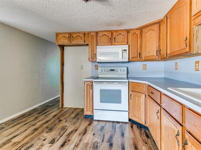 2618 NW Apache Rd, Piedmont, OK 73078 - kitchen featuring white appliances, dark wood-type flooring, a textured ceiling, brown cabinets, and light countertops