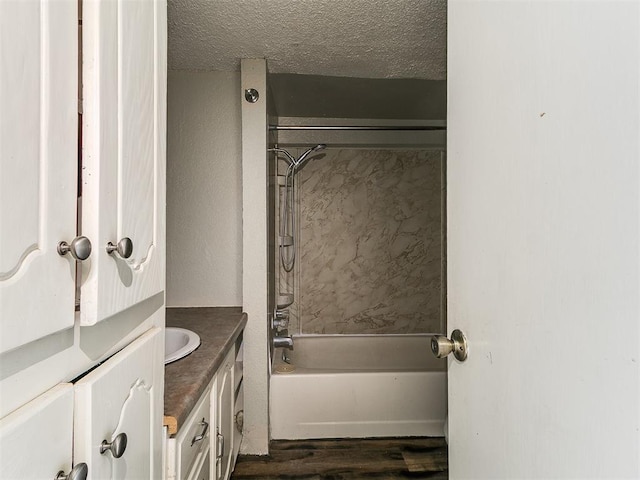 2618 NW Apache Rd, Piedmont, OK 73078 - bathroom featuring vanity, washtub / shower combination, a textured ceiling, and wood finished floors