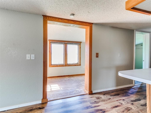 2618 NW Apache Rd, Piedmont, OK 73078 - hallway with wood finished floors, a textured ceiling, and a textured wall