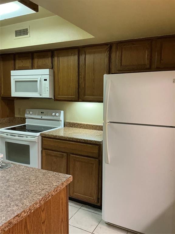 600 NW 4th St Unit 305N, Oklahoma City, OK 73102 - kitchen with white appliances, light tile patterned floors, and light countertops