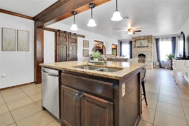 7007 NW 61st St, Bethany, OK 73008 - kitchen featuring dishwasher, ceiling fan, a stone fireplace, a barn door, and a center island with sink