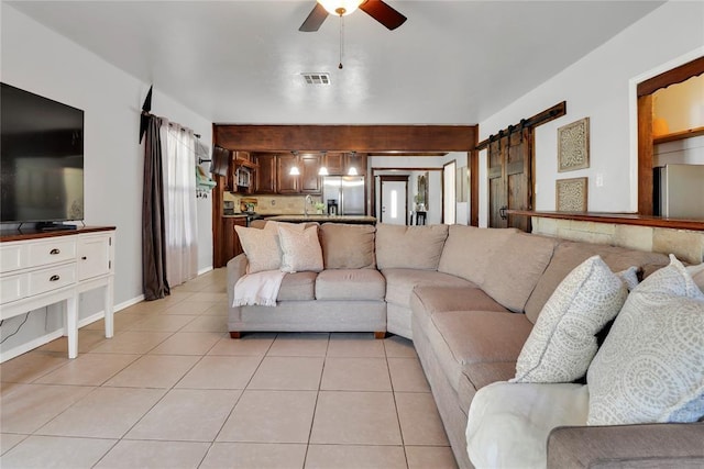 7007 NW 61st St, Bethany, OK 73008 - living area with a barn door, light tile patterned flooring, and ceiling fan