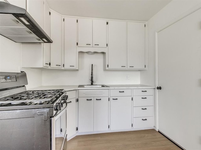 2340 SW 46th St, Oklahoma City, OK 73119 - kitchen with stainless steel gas range, extractor fan, light wood-style floors, and white cabinets