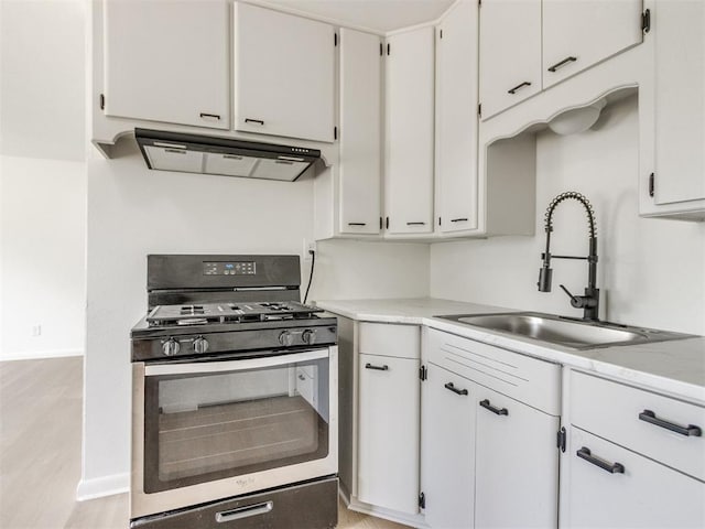 2340 SW 46th St, Oklahoma City, OK 73119 - kitchen featuring gas range, ventilation hood, white cabinetry, and light wood finished floors