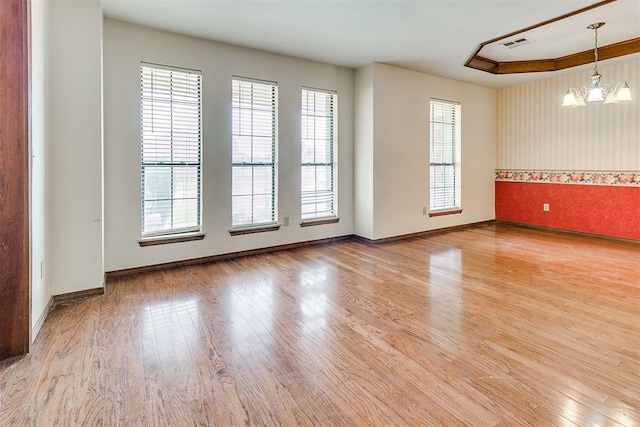 10201 Mantle Ct, Oklahoma City, OK 73162 - spare room with healthy amount of natural light, wood finished floors, and a chandelier