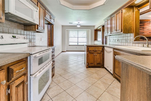 10201 Mantle Ct, Oklahoma City, OK 73162 - kitchen with white appliances, backsplash, brown cabinetry, light countertops, and a peninsula
