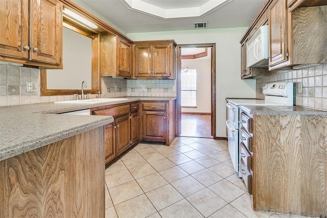 10201 Mantle Ct, Oklahoma City, OK 73162 - kitchen with white appliances, decorative backsplash, brown cabinetry, and light countertops