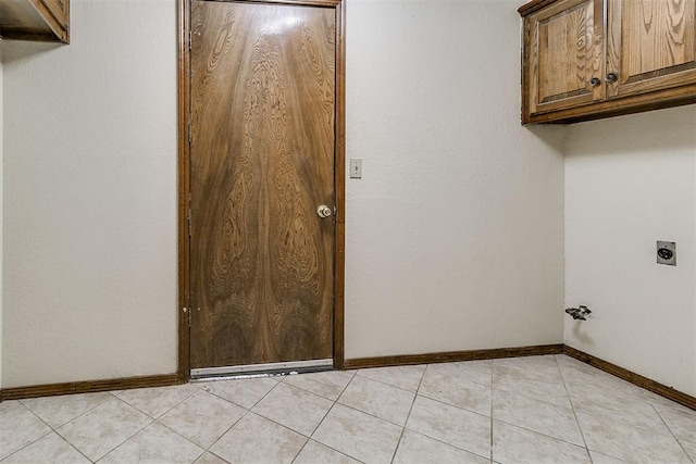 10201 Mantle Ct, Oklahoma City, OK 73162 - washroom with electric dryer hookup, cabinet space, and light tile patterned floors