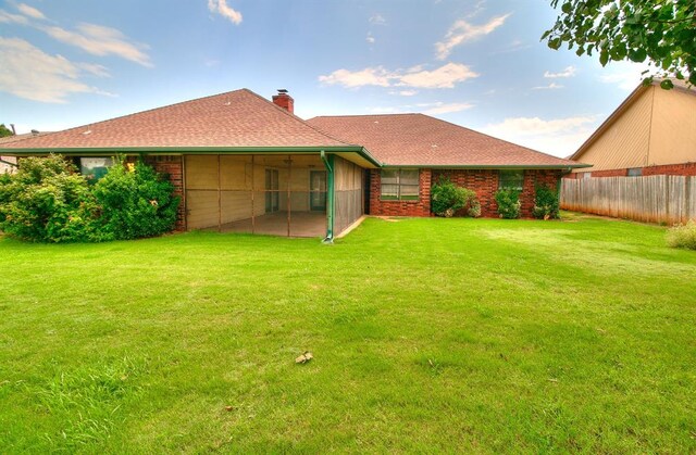 10201 Mantle Ct, Oklahoma City, OK 73162 - rear view of property featuring a chimney, a sunroom, a shingled roof, and brick siding