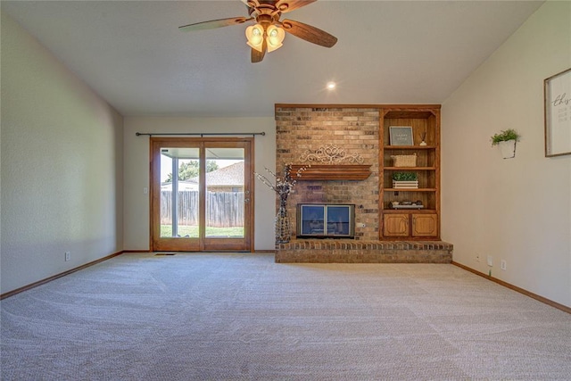 2109 Shamrock Dr, Edmond, OK 73003 - unfurnished living room featuring carpet floors, a ceiling fan, built in features, and a brick fireplace
