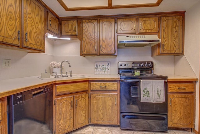 2109 Shamrock Dr, Edmond, OK 73003 - kitchen with under cabinet range hood, black appliances, light countertops, and brown cabinetry