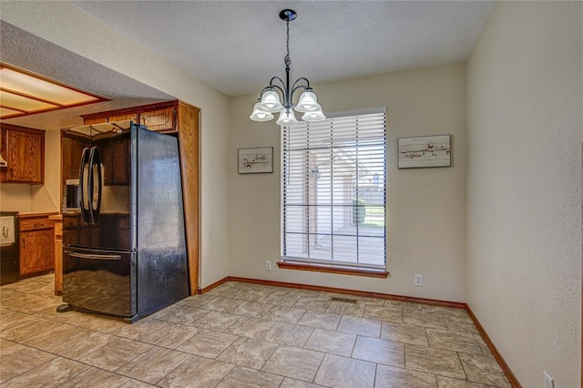 2109 Shamrock Dr, Edmond, OK 73003 - unfurnished dining area featuring a chandelier and a textured ceiling
