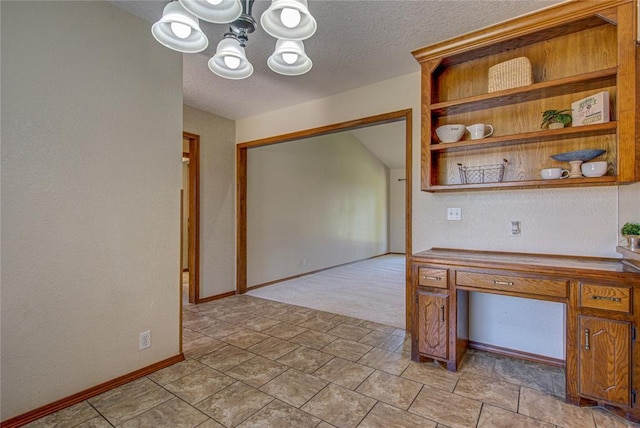 2109 Shamrock Dr, Edmond, OK 73003 - unfurnished dining area featuring a chandelier and a textured ceiling