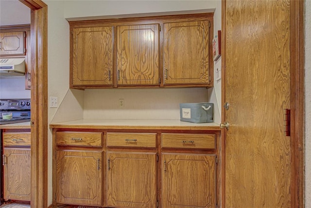 2109 Shamrock Dr, Edmond, OK 73003 - kitchen with light countertops, exhaust hood, electric range, and brown cabinets