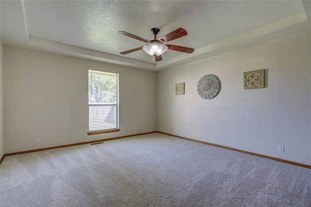 2109 Shamrock Dr, Edmond, OK 73003 - unfurnished room with carpet floors, a ceiling fan, a textured ceiling, and a tray ceiling