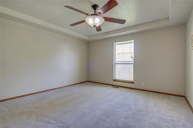 2109 Shamrock Dr, Edmond, OK 73003 - unfurnished room featuring light colored carpet, a raised ceiling, ceiling fan, and a textured ceiling