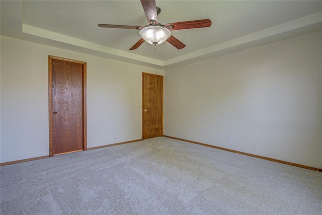 2109 Shamrock Dr, Edmond, OK 73003 - empty room with a raised ceiling, ceiling fan, and carpet