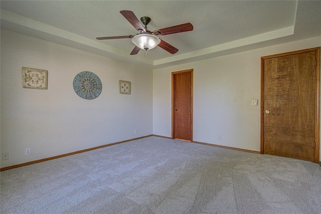 2109 Shamrock Dr, Edmond, OK 73003 - spare room with carpet, a ceiling fan, and a raised ceiling