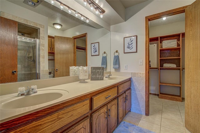 2109 Shamrock Dr, Edmond, OK 73003 - full bath featuring double vanity, tile patterned flooring, a shower stall, and a walk in closet