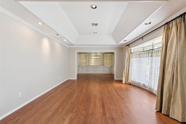 3000 Middlesex Dr, Oklahoma City, OK 73120 - empty room with a tray ceiling, wood finished floors, crown molding, recessed lighting, and built in features