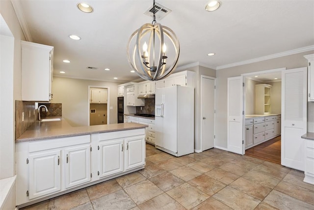 3000 Middlesex Dr, Oklahoma City, OK 73120 - kitchen with white fridge with ice dispenser, stainless steel gas stovetop, decorative backsplash, crown molding, and recessed lighting