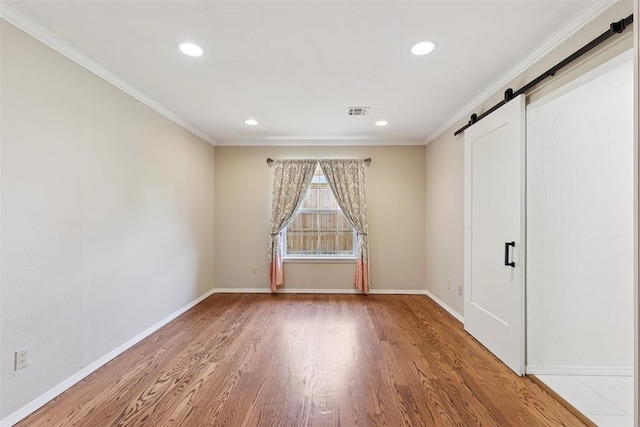 3000 Middlesex Dr, Oklahoma City, OK 73120 - empty room with a barn door, wood finished floors, ornamental molding, and recessed lighting