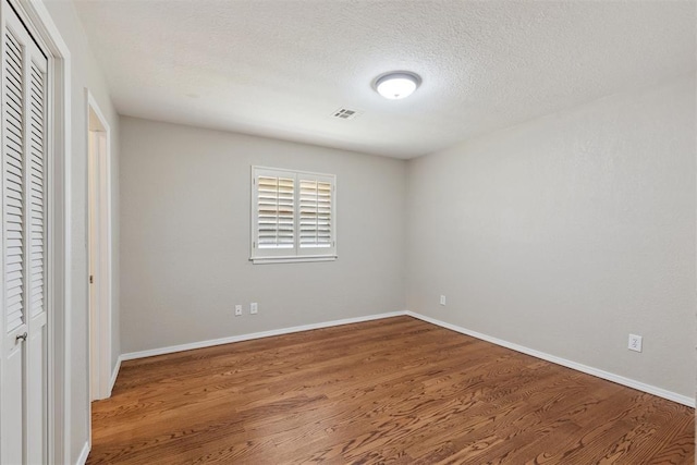 3000 Middlesex Dr, Oklahoma City, OK 73120 - unfurnished bedroom with wood finished floors, a closet, and a textured ceiling