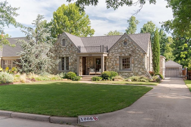1005 NW 40th St, Oklahoma City, OK 73118 - tudor-style house with stone siding, a gate, and a front yard