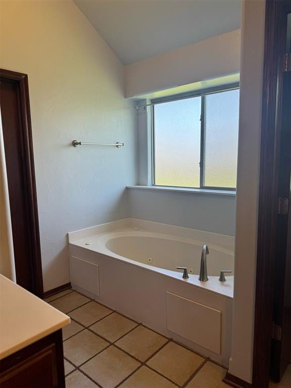 9209 SW 28th St, Oklahoma City, OK 73128 - bathroom with a tub with jets, tile patterned floors, vanity, and lofted ceiling