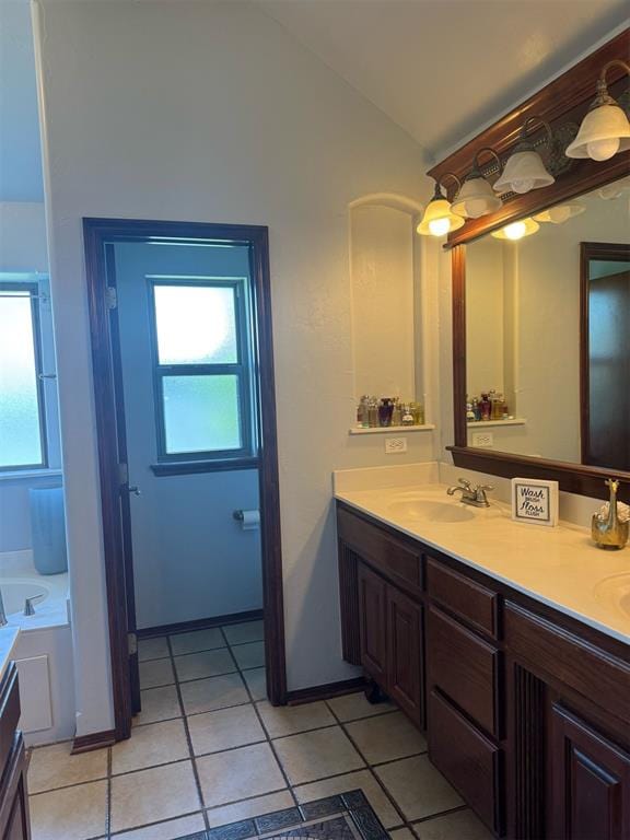 9209 SW 28th St, Oklahoma City, OK 73128 - bathroom with double vanity, healthy amount of natural light, tile patterned floors, lofted ceiling, and a tub