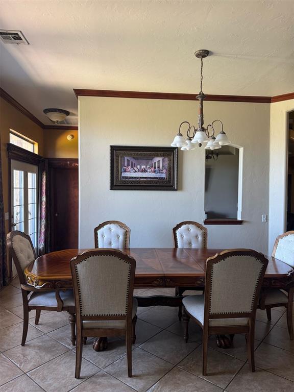 9209 SW 28th St, Oklahoma City, OK 73128 - dining area featuring crown molding, a chandelier, and light tile patterned floors