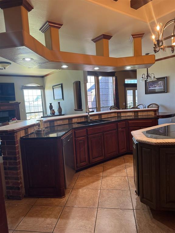 9209 SW 28th St, Oklahoma City, OK 73128 - kitchen with black appliances, a chandelier, healthy amount of natural light, light tile patterned floors, and ornamental molding