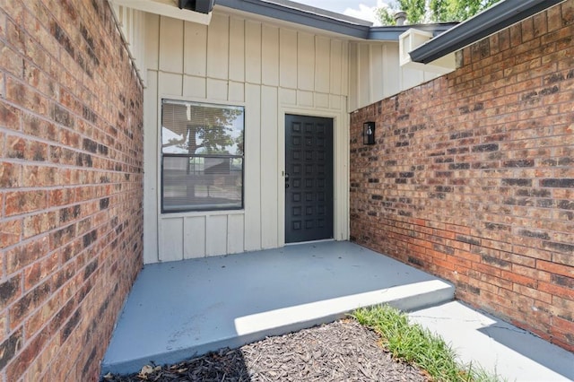 2322 Ripple Creek Ln, Edmond, OK 73012 - view of exterior entry with board and batten siding and brick siding