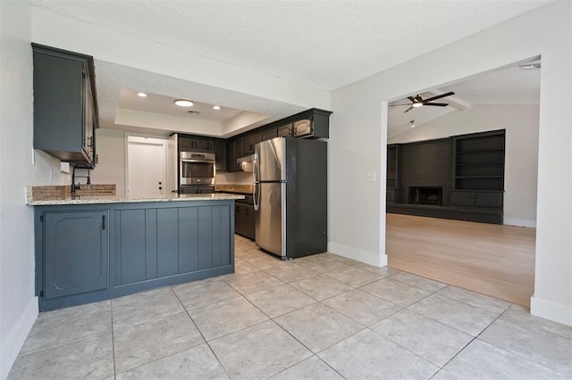 2322 Ripple Creek Ln, Edmond, OK 73012 - kitchen with stainless steel appliances, a peninsula, open floor plan, ceiling fan, and vaulted ceiling