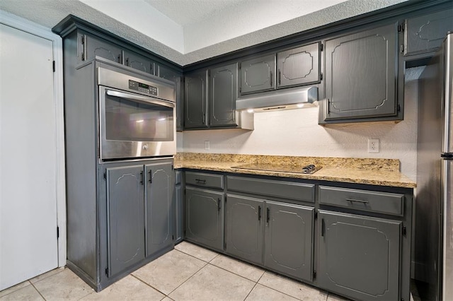 2322 Ripple Creek Ln, Edmond, OK 73012 - kitchen with appliances with stainless steel finishes, under cabinet range hood, and light tile patterned floors