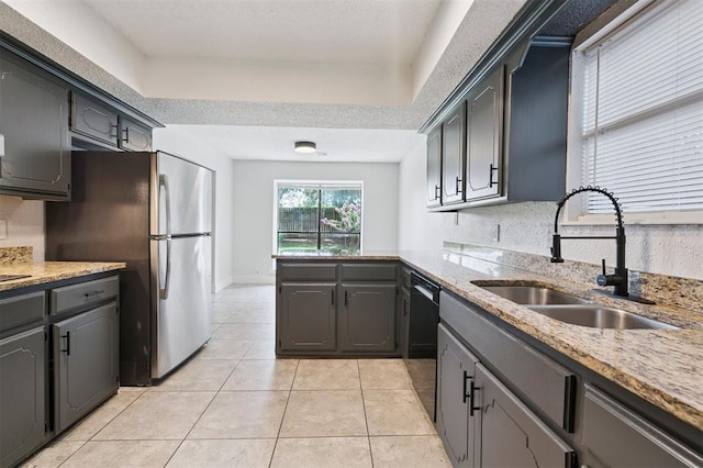 2322 Ripple Creek Ln, Edmond, OK 73012 - kitchen featuring freestanding refrigerator, light tile patterned flooring, a peninsula, dishwasher, and light stone counters