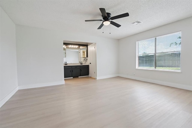 2322 Ripple Creek Ln, Edmond, OK 73012 - empty room with light wood-style floors, a ceiling fan, and a textured ceiling